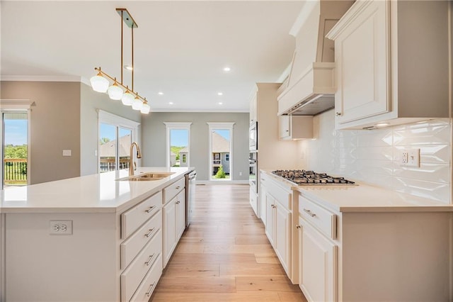 7009 NE 103rd St, Kansas City, MO 64156 - kitchen featuring an island with sink, decorative backsplash, stainless steel appliances, light countertops, and light wood-style flooring