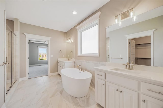 7009 NE 103rd St, Kansas City, MO 64156 - full bath featuring a soaking tub, two vanities, a stall shower, marble finish flooring, and a spacious closet