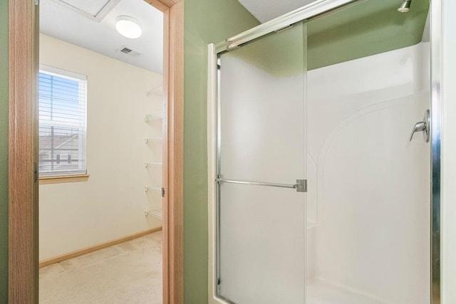 bathroom with a stall shower, visible vents, and baseboards