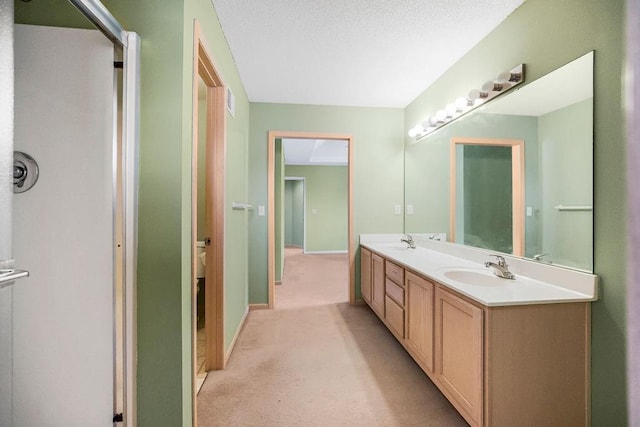 bathroom with a sink, a textured ceiling, baseboards, and double vanity