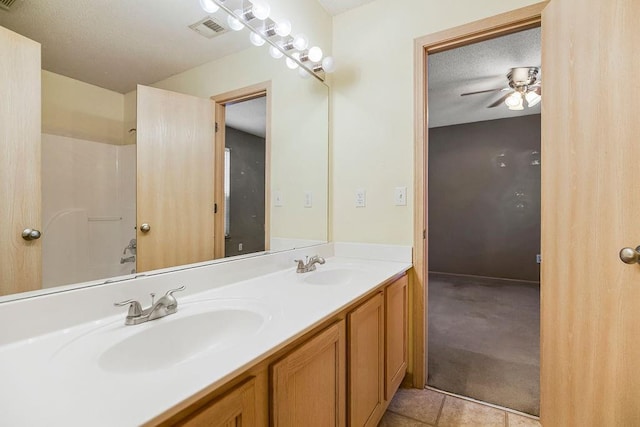 full bath featuring double vanity, a ceiling fan, visible vents, and a sink