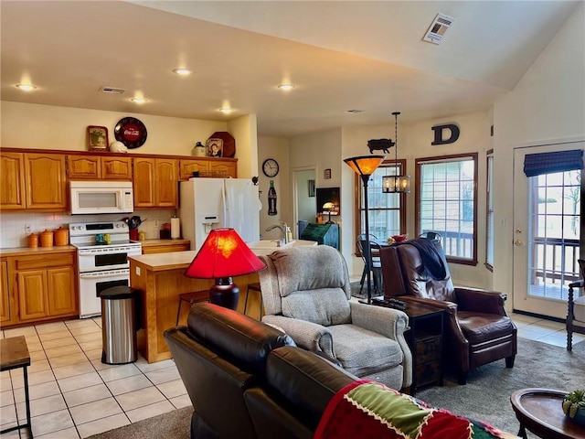 kitchen with white appliances, visible vents, open floor plan, and light countertops