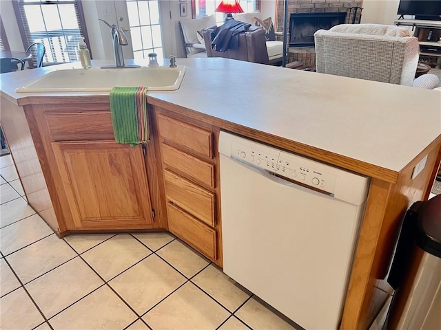 kitchen featuring light tile patterned floors, light countertops, open floor plan, a sink, and dishwasher