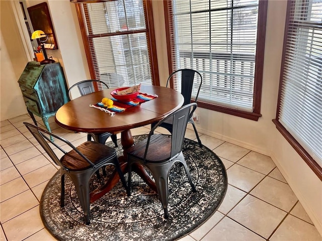 dining space with baseboards and light tile patterned floors