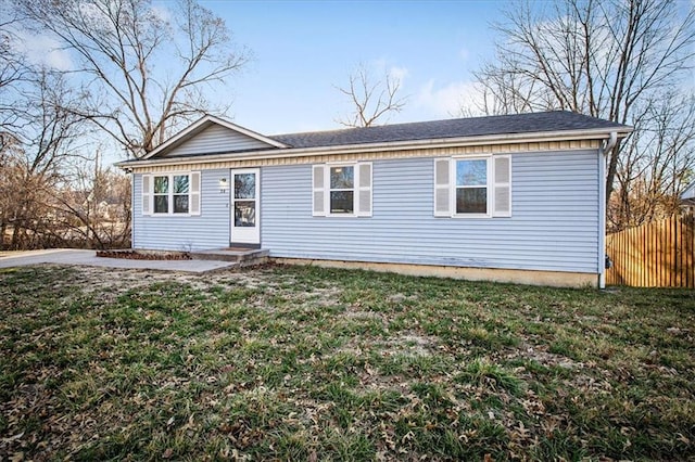 ranch-style house featuring a front yard and fence