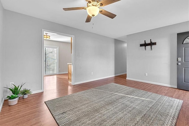 interior space with ceiling fan, baseboards, and wood finished floors