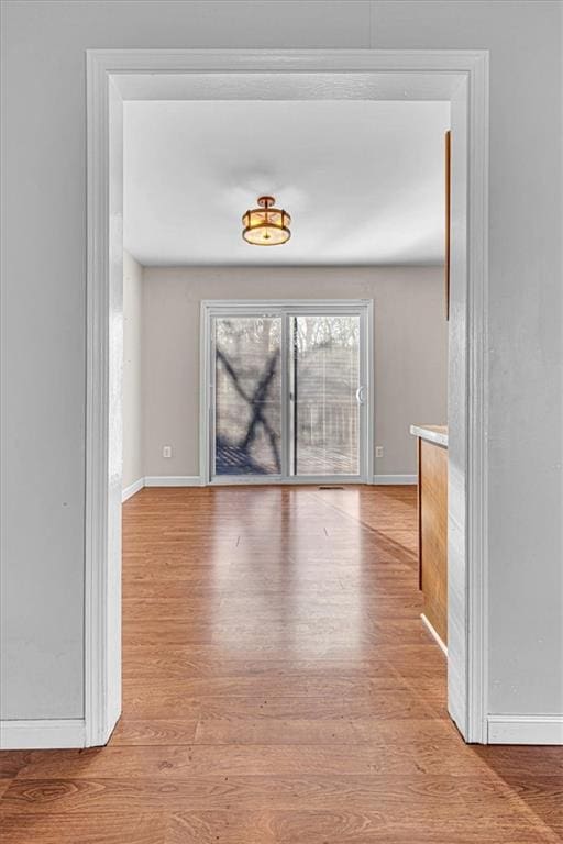 spare room featuring wood finished floors and baseboards