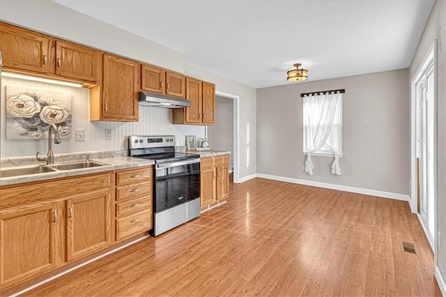 kitchen featuring visible vents, a sink, light countertops, electric stove, and under cabinet range hood