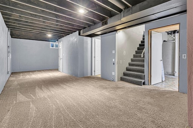 basement featuring stairs and carpet