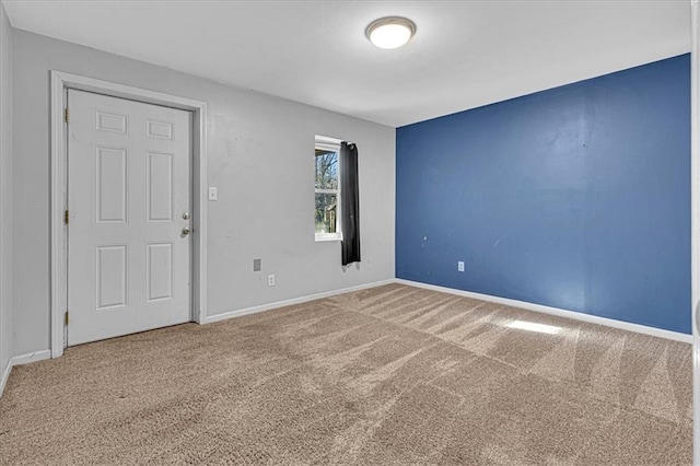 unfurnished room featuring baseboards and carpet