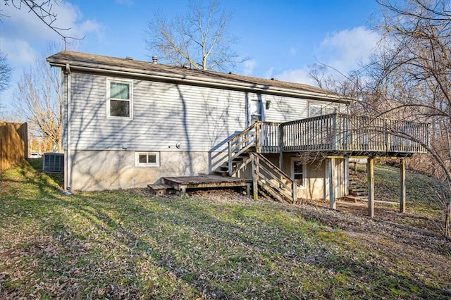 rear view of house with a lawn, central AC, fence, stairway, and a wooden deck