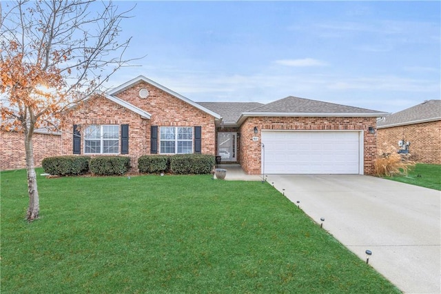 single story home with brick siding, concrete driveway, roof with shingles, an attached garage, and a front yard