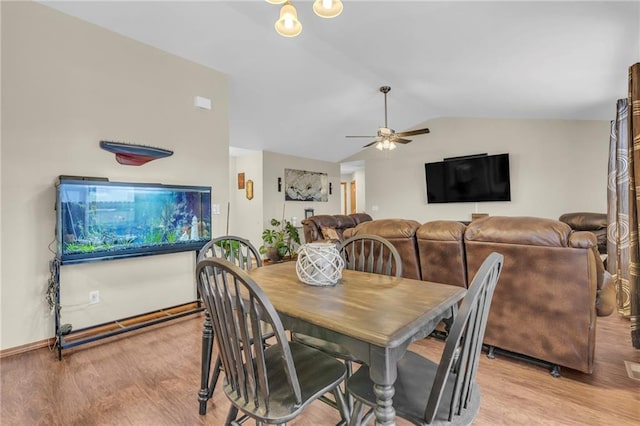 dining area with light wood-type flooring, vaulted ceiling, and a ceiling fan