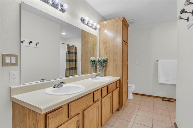 bathroom with toilet, visible vents, a sink, and tile patterned floors