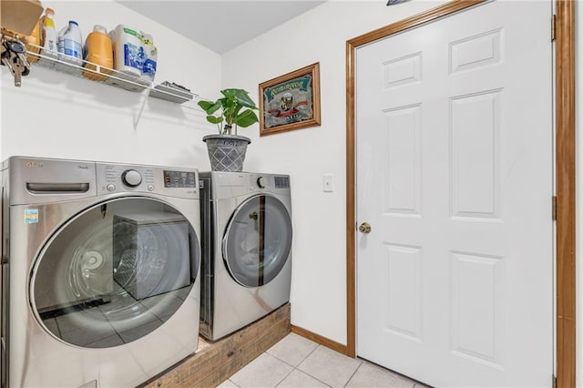 laundry area with light tile patterned floors, laundry area, independent washer and dryer, and baseboards