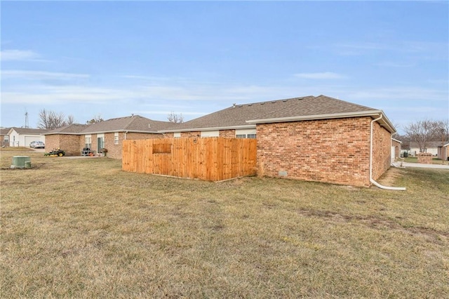 view of yard featuring fence and central AC