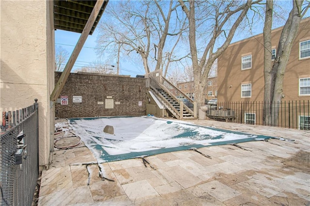 view of swimming pool featuring a patio area, stairs, and fence