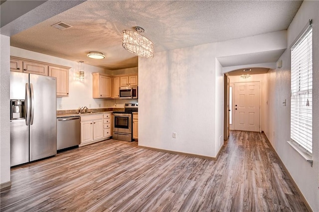 kitchen with a sink, stainless steel appliances, visible vents, and light wood-style flooring