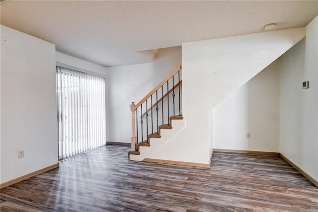 interior space featuring stairway, baseboards, and wood finished floors