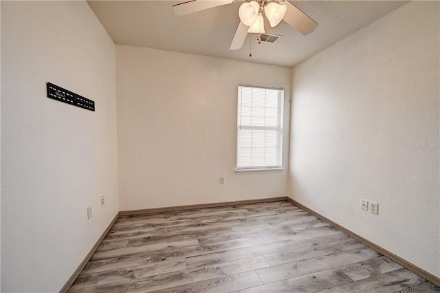 spare room with visible vents, baseboards, ceiling fan, and light wood finished floors