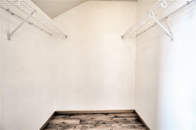 walk in closet featuring lofted ceiling and wood finished floors