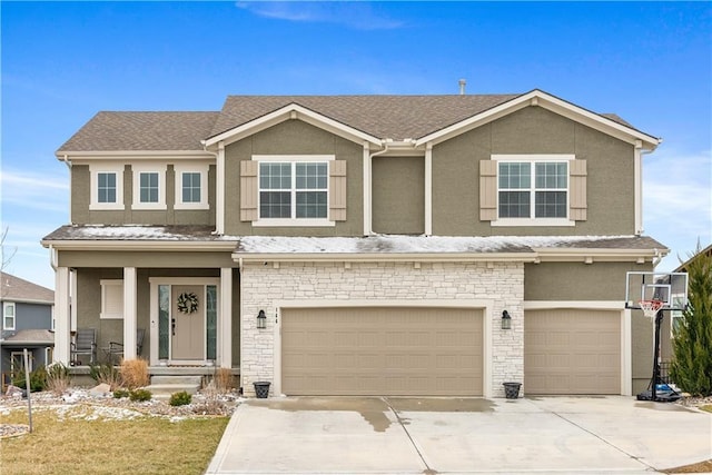 view of front of house featuring stone siding, stucco siding, an attached garage, and driveway