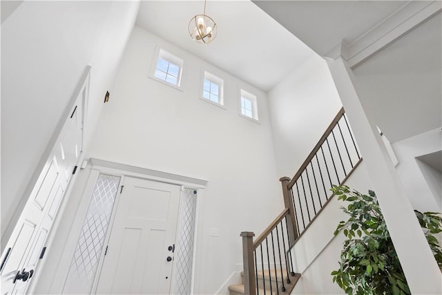 entryway featuring stairway and a towering ceiling