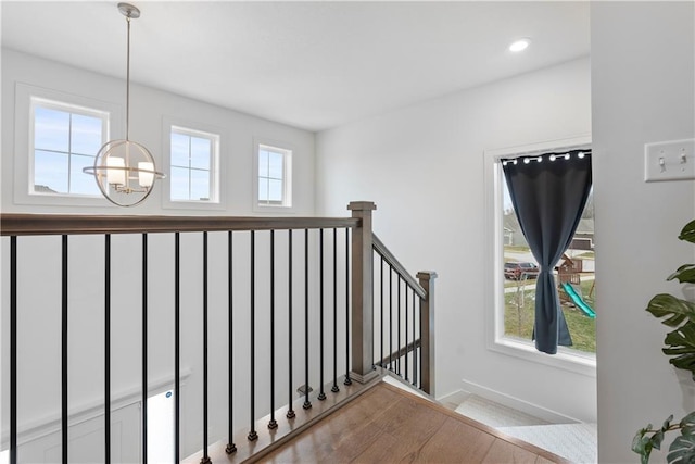 stairway with recessed lighting, a notable chandelier, and wood finished floors