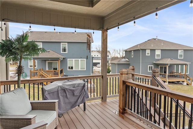 wooden terrace featuring grilling area and a residential view