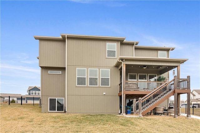 back of property featuring fence, a ceiling fan, a yard, stairs, and a deck