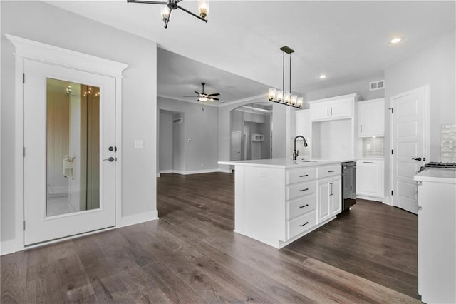 kitchen with visible vents, white cabinets, dark wood-style floors, open floor plan, and a sink