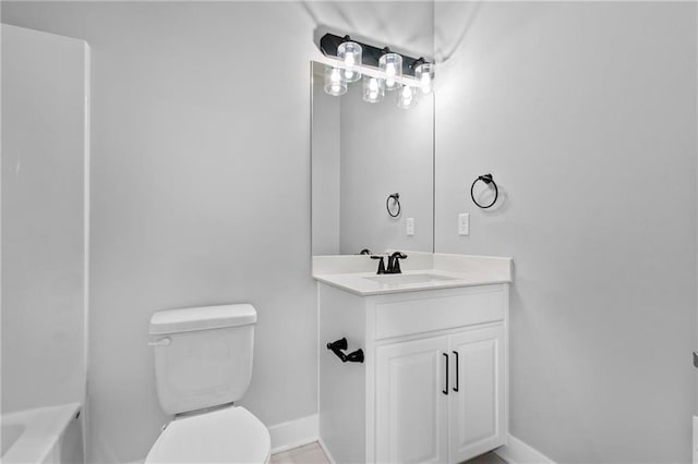 bathroom with baseboards, vanity, and toilet