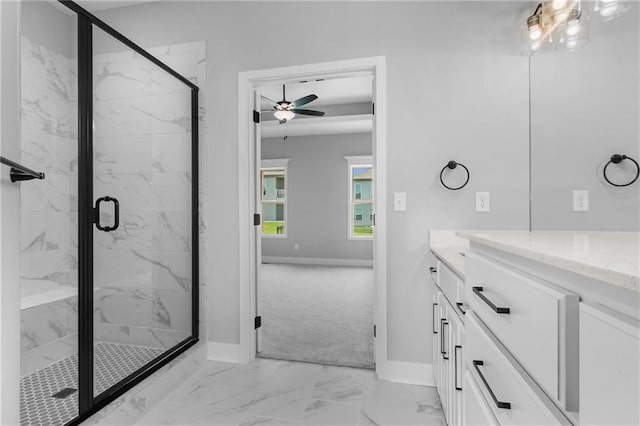 bathroom featuring marble finish floor, a marble finish shower, vanity, and baseboards