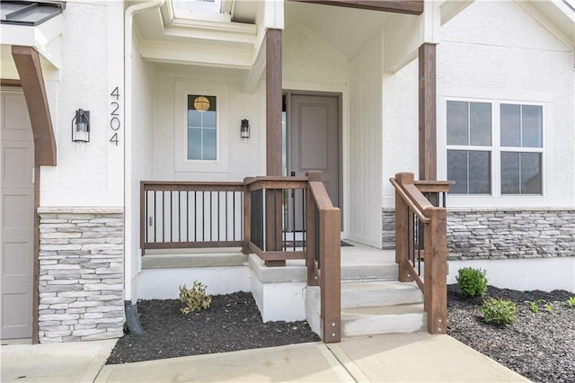 property entrance featuring covered porch, stone siding, and stucco siding