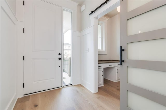 foyer featuring a barn door and light wood-style floors