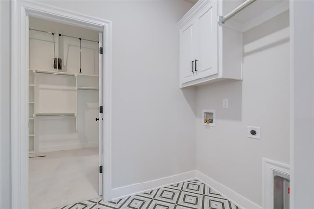 laundry room featuring hookup for an electric dryer, washer hookup, baseboards, cabinet space, and tile patterned floors