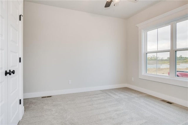 spare room featuring baseboards, visible vents, and carpet flooring