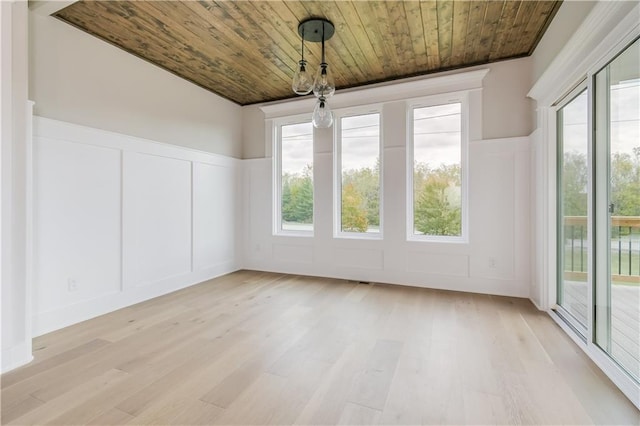 interior space with light wood-type flooring, wood ceiling, a decorative wall, and wainscoting