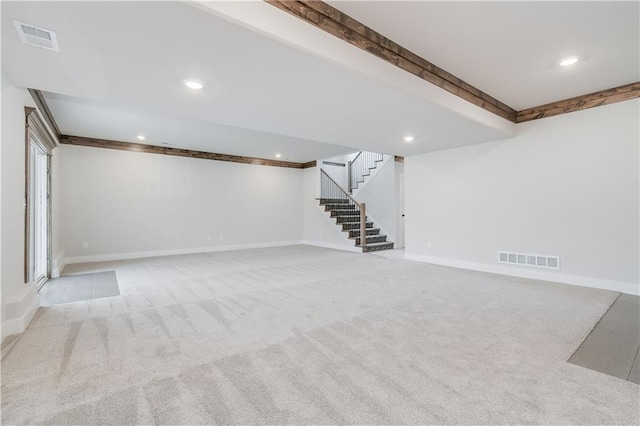 finished below grade area with stairs, carpet flooring, visible vents, and baseboards