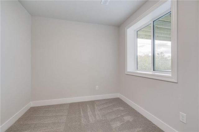 empty room featuring carpet and baseboards