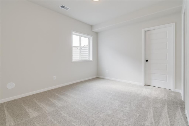 carpeted spare room featuring visible vents and baseboards