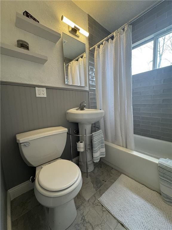 10904 Cambridge Ave, Kansas City, MO 64134 - full bath featuring marble finish floor, wainscoting, shower / bathtub combination with curtain, and toilet