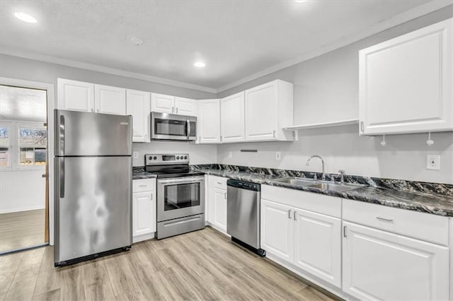 kitchen with light wood-style flooring, a sink, stainless steel appliances, white cabinetry, and crown molding