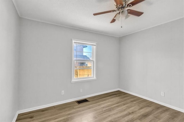 unfurnished room with visible vents, baseboards, a ceiling fan, and wood finished floors