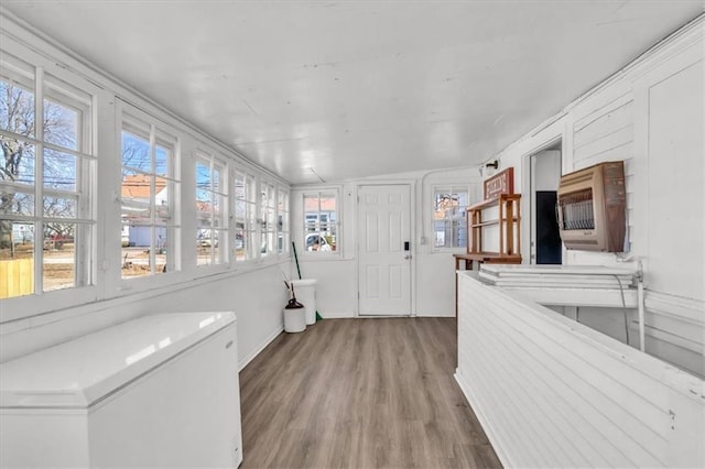 sunroom featuring heating unit and a healthy amount of sunlight