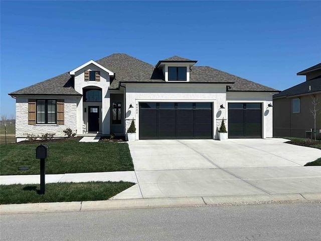 view of front facade featuring a garage, a front yard, concrete driveway, and roof with shingles