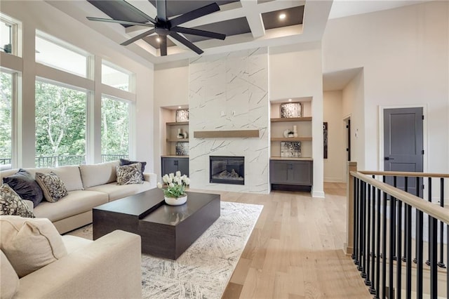 12435 NW Arbor Way, Platte City, MO 64079 - living room featuring healthy amount of natural light, a towering ceiling, coffered ceiling, a ceiling fan, and built in features
