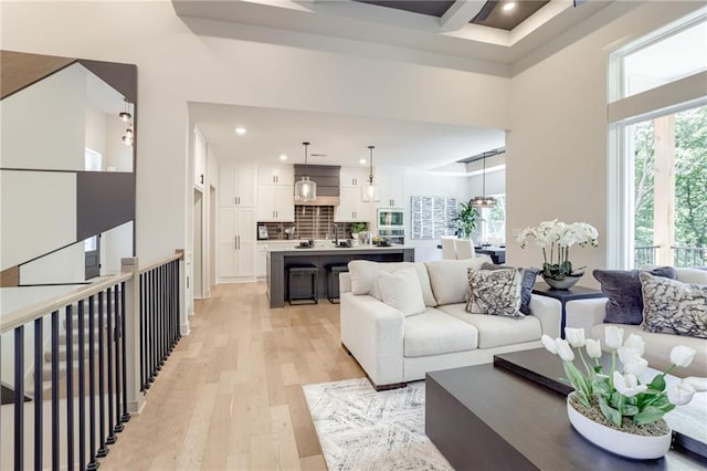 12435 NW Arbor Way, Platte City, MO 64079 - living room featuring light wood-style floors, healthy amount of natural light, recessed lighting, and a high ceiling