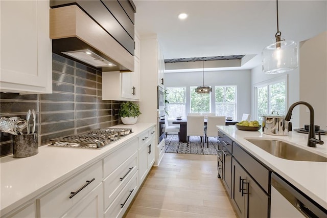 12435 NW Arbor Way, Platte City, MO 64079 - kitchen featuring appliances with stainless steel finishes, wall chimney range hood, hanging light fixtures, light countertops, and recessed lighting