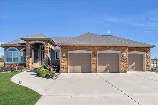 view of front of home featuring roof with shingles, driveway, and an attached garage